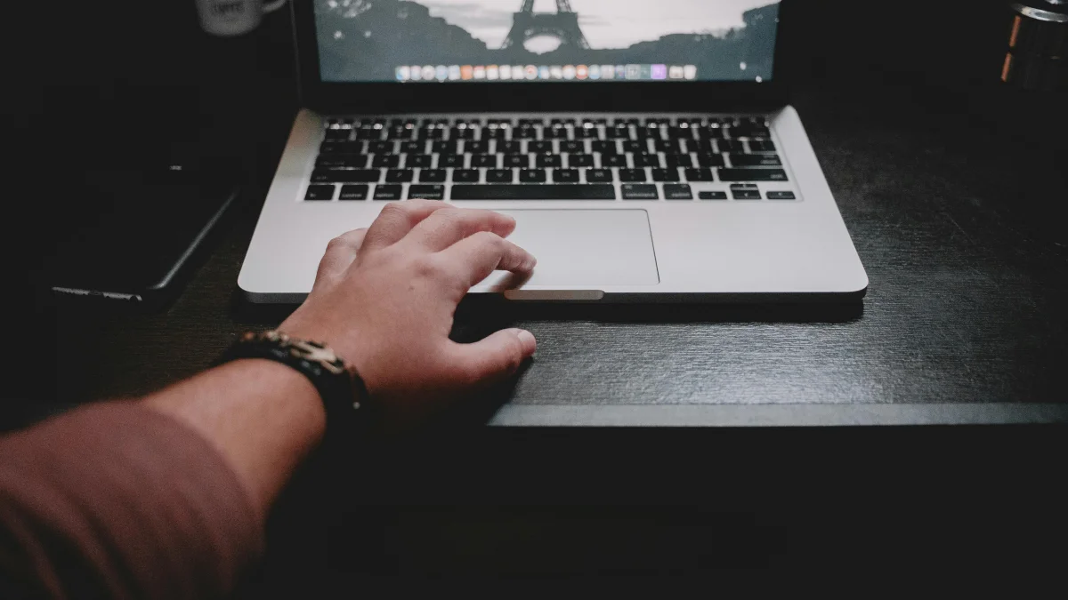 A hand touching a macbook trackpad