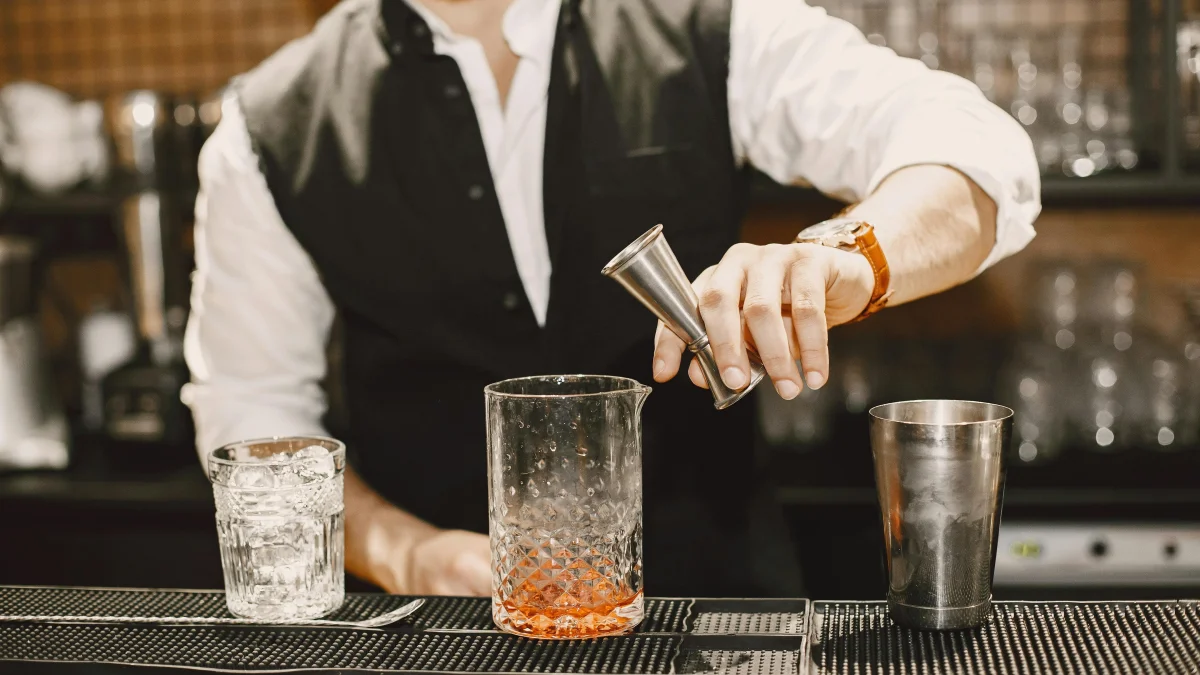 A bartender wearing a suit and mixing cocktails
