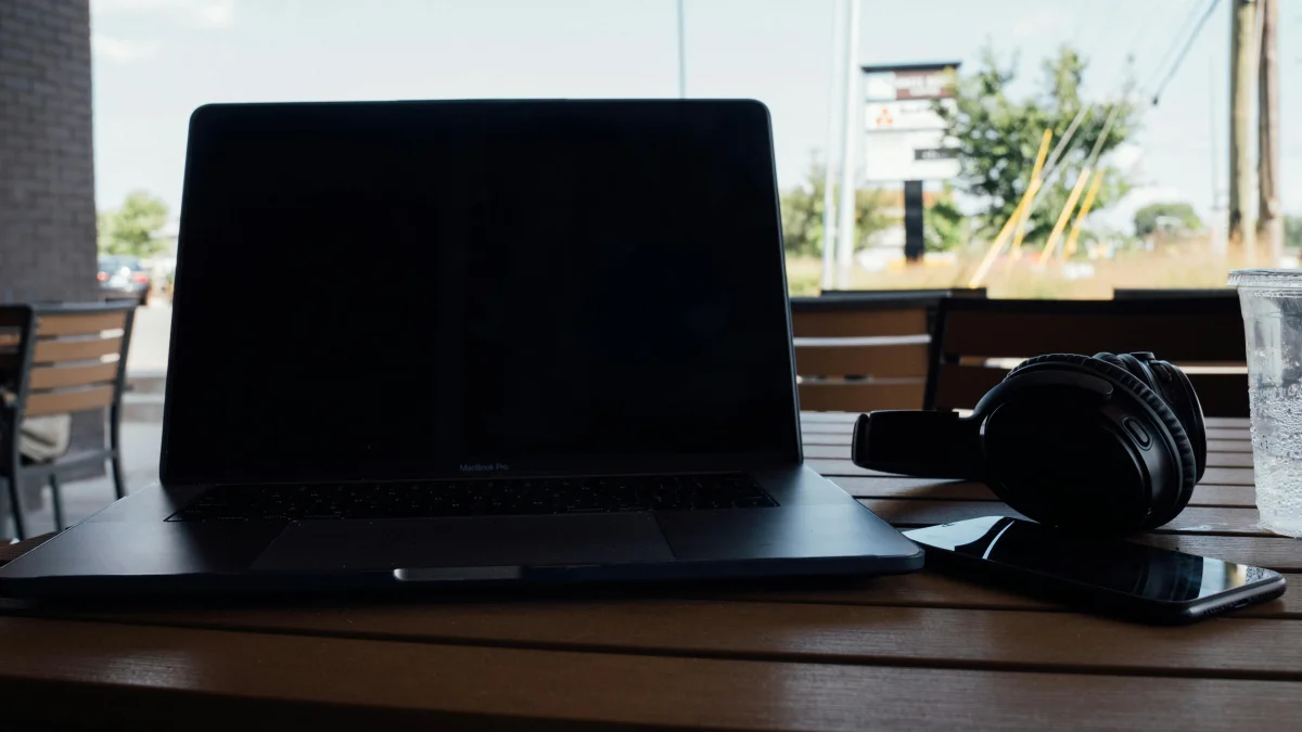 A macbophone and headphones on a wooden table