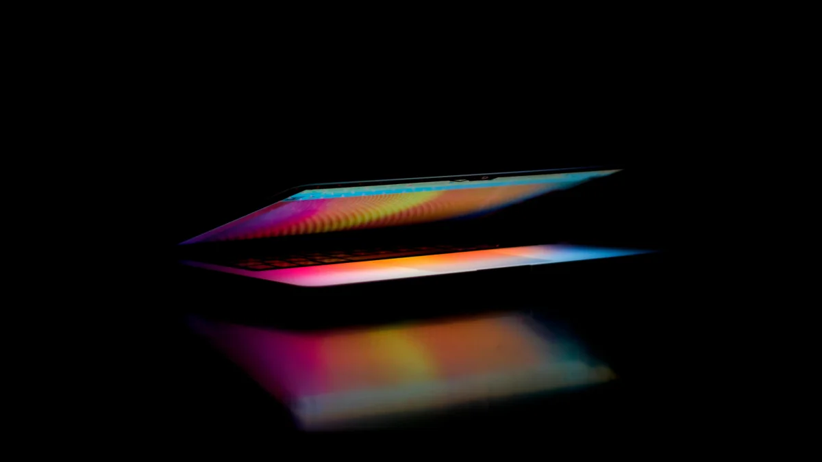 An artistic display of a Macbook in the dark with vivid colors